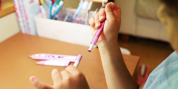 子どもがサクラクレパスの補助軸を取り外している画像